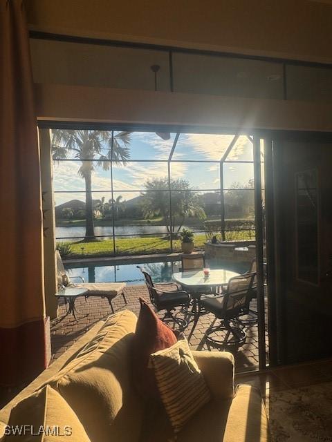 sunroom featuring a water view