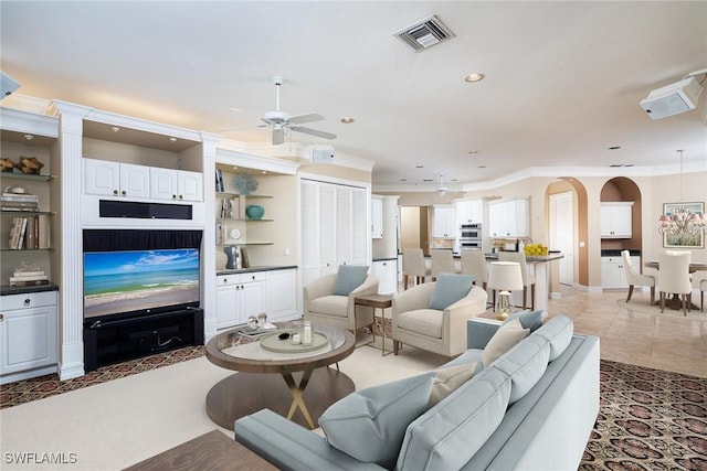 tiled living room featuring ceiling fan and crown molding