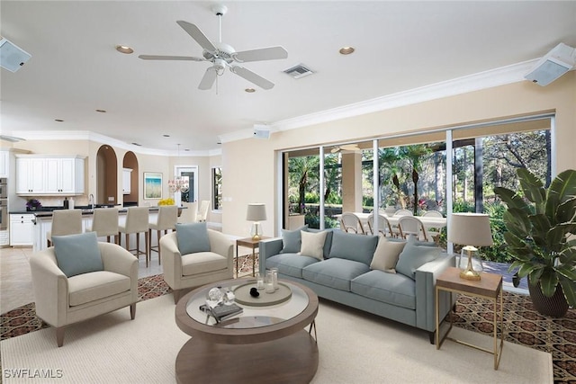 living room with ceiling fan and ornamental molding