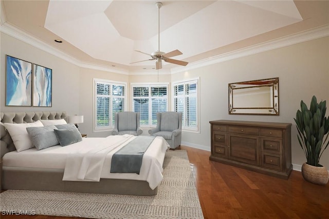 bedroom with ceiling fan, crown molding, a tray ceiling, and dark hardwood / wood-style flooring