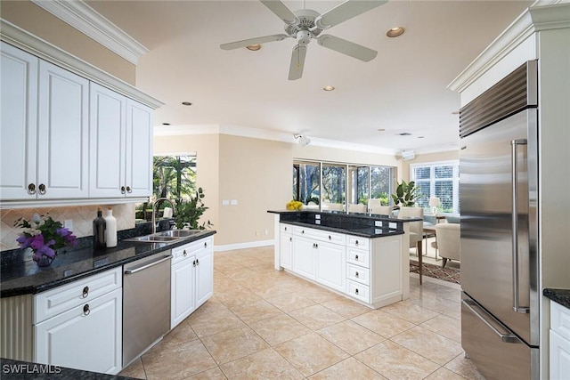 kitchen with sink, ornamental molding, white cabinets, and stainless steel appliances