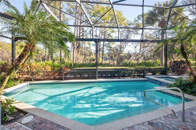 view of pool with an in ground hot tub and glass enclosure