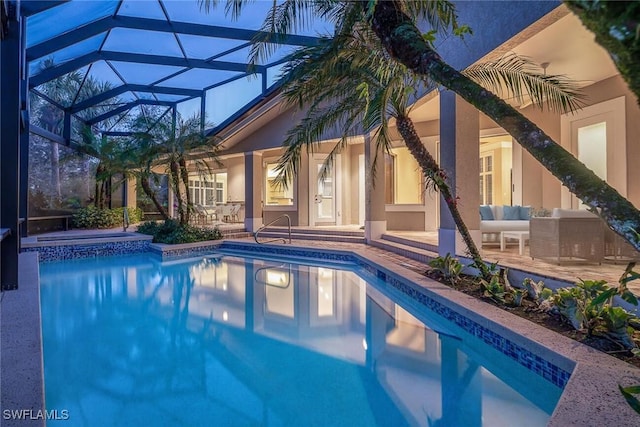 view of pool with an in ground hot tub, a patio area, a lanai, and an outdoor hangout area