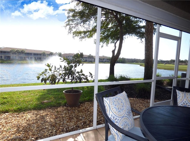 sunroom / solarium featuring a water view