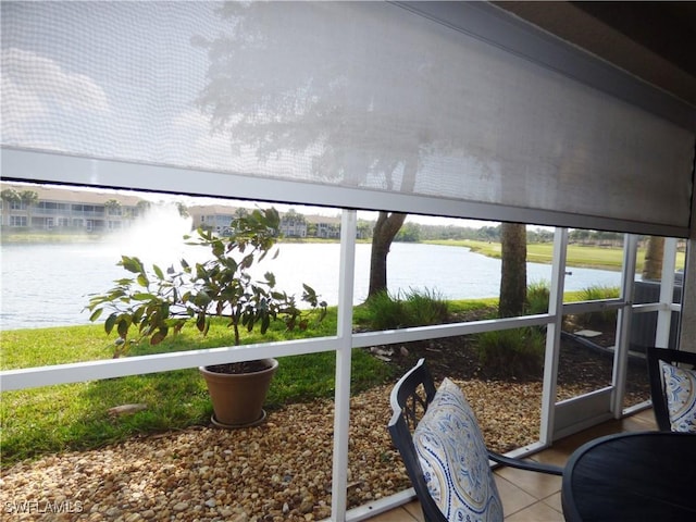 sunroom / solarium featuring a water view