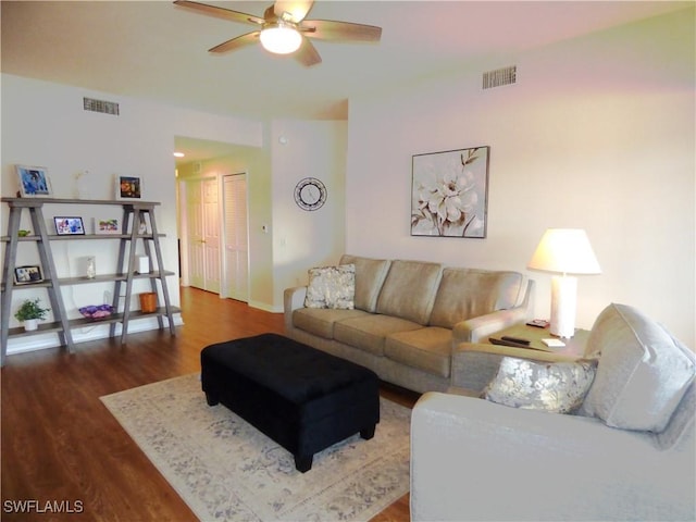 living room with dark wood-type flooring and ceiling fan