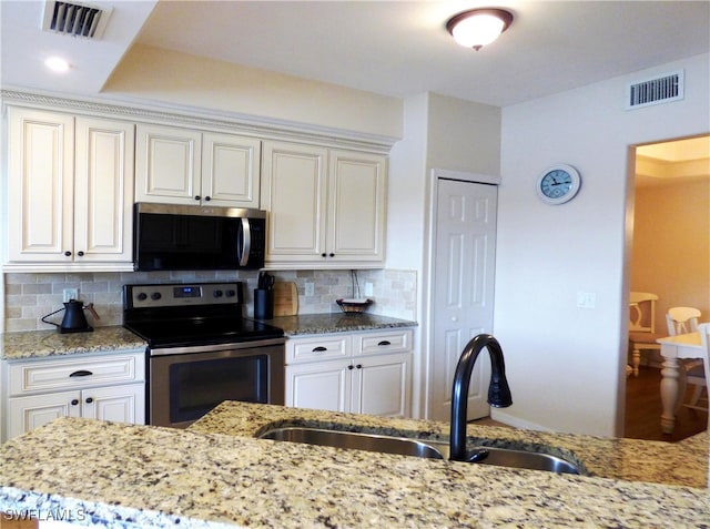 kitchen with sink, decorative backsplash, light stone countertops, and appliances with stainless steel finishes