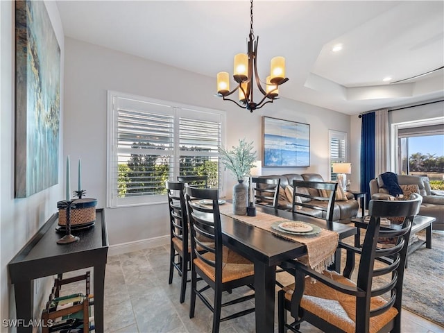 dining room with a notable chandelier and a tray ceiling