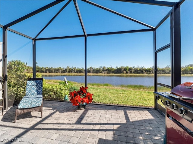 view of patio featuring a lanai and a water view