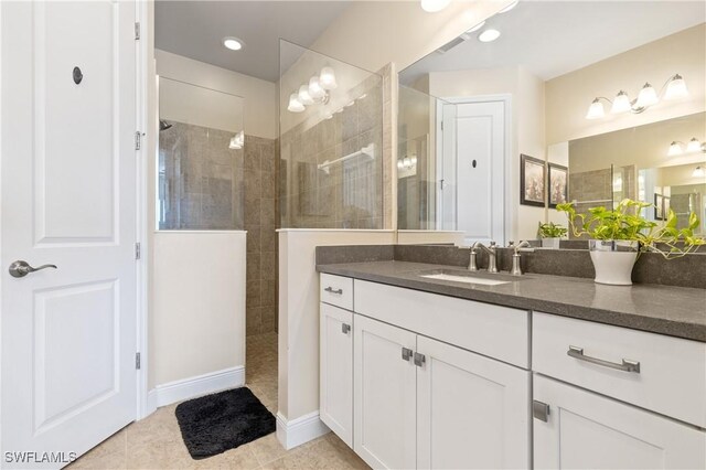 bathroom with vanity, tile patterned flooring, and tiled shower