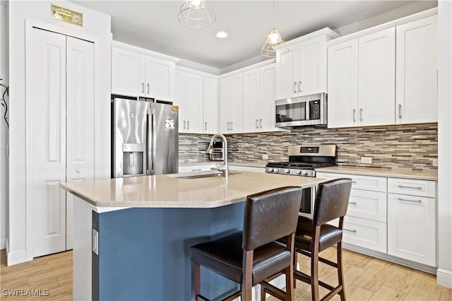 kitchen with white cabinetry, sink, a center island with sink, and appliances with stainless steel finishes