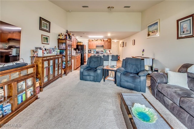 carpeted living room featuring a towering ceiling