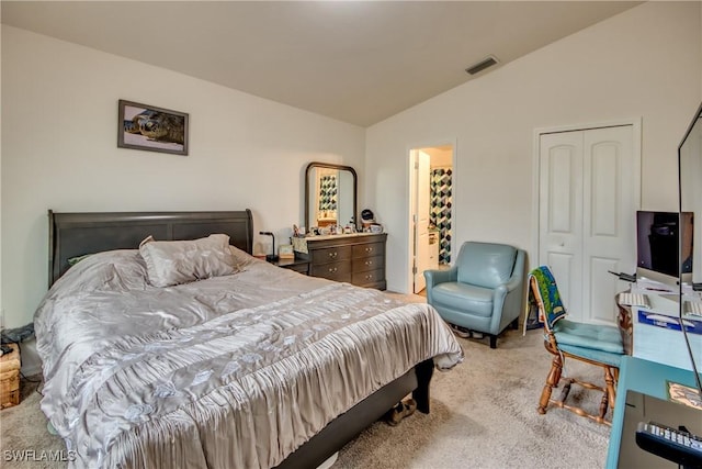 carpeted bedroom featuring lofted ceiling and a closet