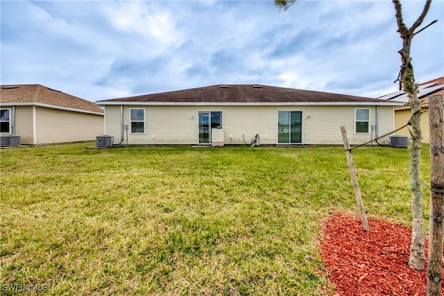 back of property featuring central AC and a lawn