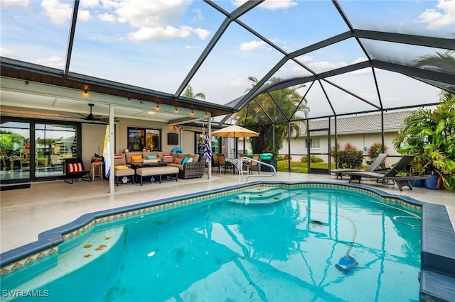 outdoor pool with an outdoor hangout area, glass enclosure, ceiling fan, and a patio area