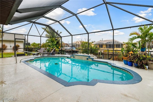 view of pool with glass enclosure, a patio area, and a hot tub