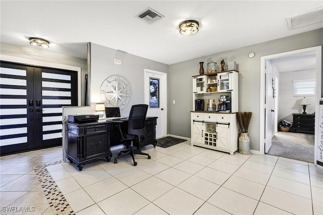 office with french doors and light tile patterned flooring