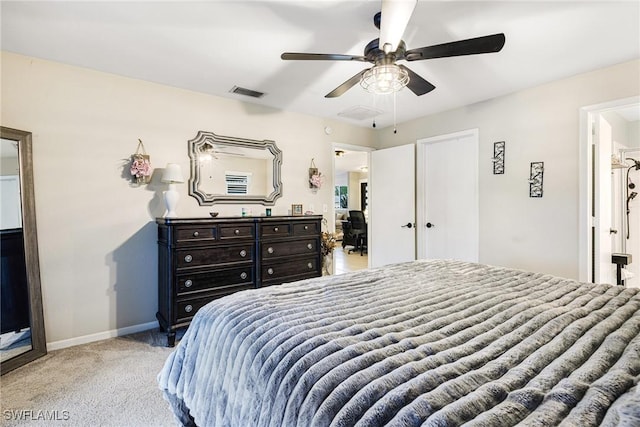 bedroom featuring ceiling fan, ensuite bath, and light carpet