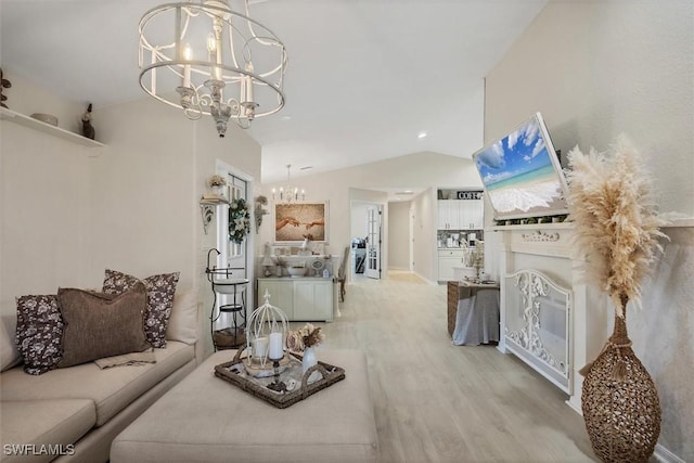 living room featuring vaulted ceiling, a chandelier, and light hardwood / wood-style floors