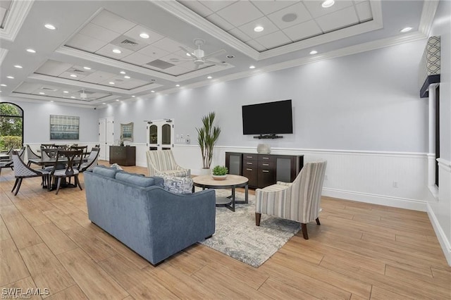 living room with light hardwood / wood-style floors, ceiling fan, and ornamental molding