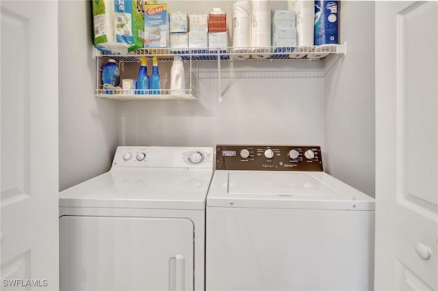 clothes washing area with washing machine and dryer