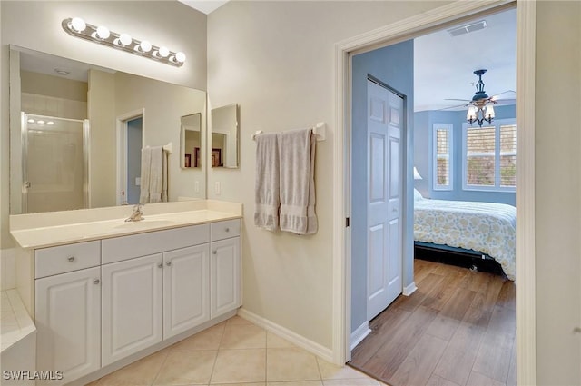 bathroom with a shower with door, ceiling fan, and vanity