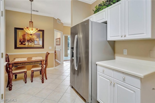 kitchen with white cabinets, decorative light fixtures, stainless steel refrigerator with ice dispenser, light tile patterned floors, and crown molding