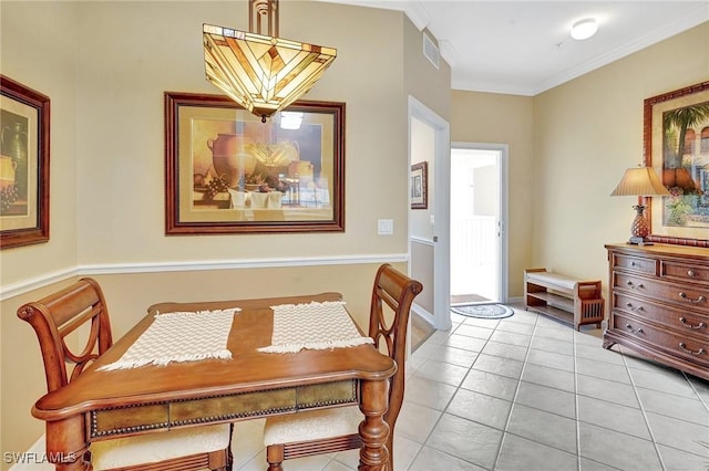 dining space with crown molding and light tile patterned floors