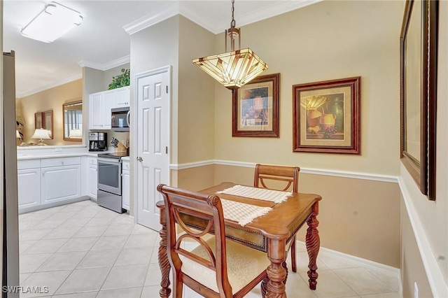 dining room featuring crown molding and light tile patterned flooring