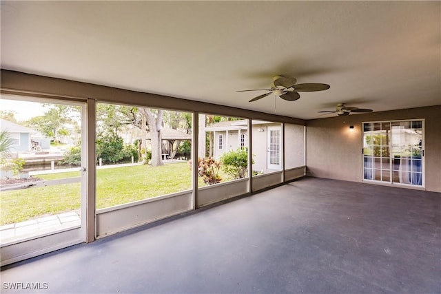 unfurnished sunroom with ceiling fan