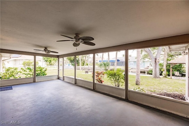 unfurnished sunroom featuring ceiling fan