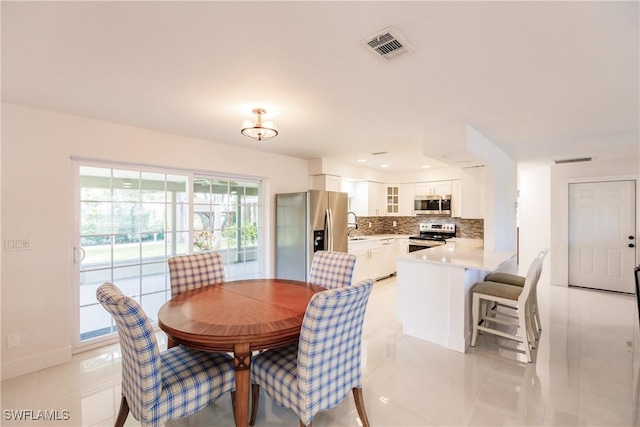 tiled dining room featuring sink