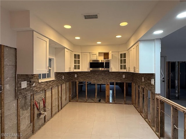 kitchen with light tile patterned floors and white cabinets