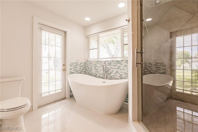 bathroom with plenty of natural light, toilet, tile patterned flooring, and plus walk in shower