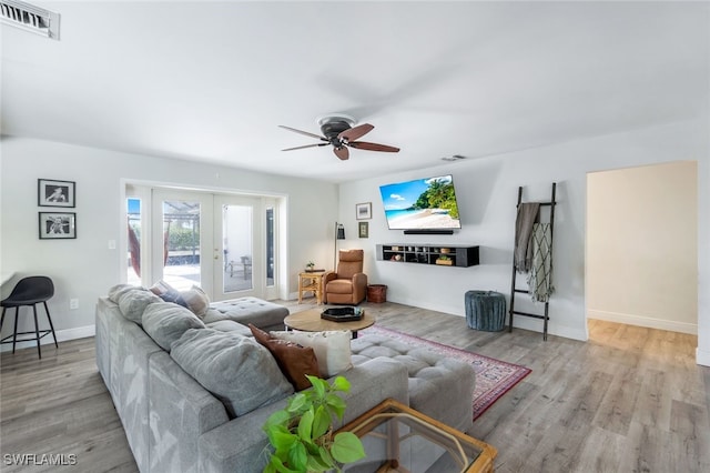 living room featuring french doors, ceiling fan, and light hardwood / wood-style floors