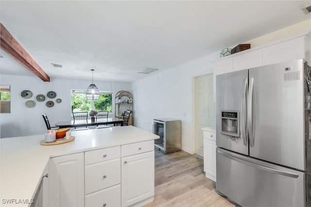 kitchen with stainless steel fridge with ice dispenser, hanging light fixtures, light wood-type flooring, beam ceiling, and white cabinets