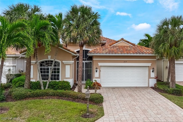 mediterranean / spanish house featuring a garage and a front yard