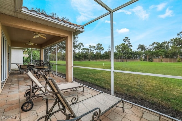 unfurnished sunroom featuring ceiling fan