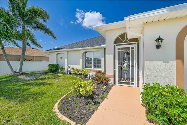 property entrance featuring a lawn