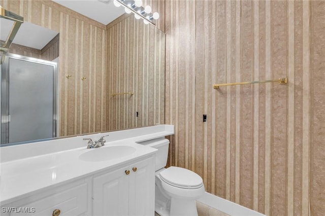 bathroom featuring vanity, toilet, and a shower with shower door