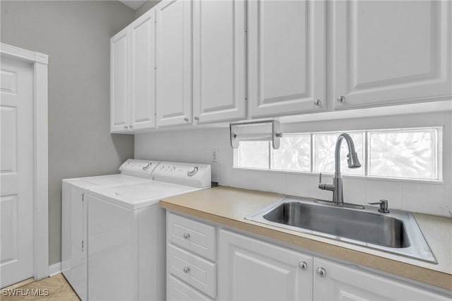 laundry room featuring sink, light tile patterned floors, cabinets, and independent washer and dryer