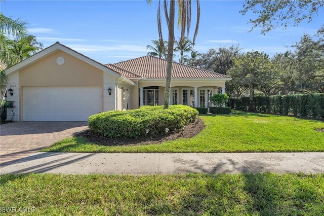 mediterranean / spanish-style home featuring a garage and a front lawn