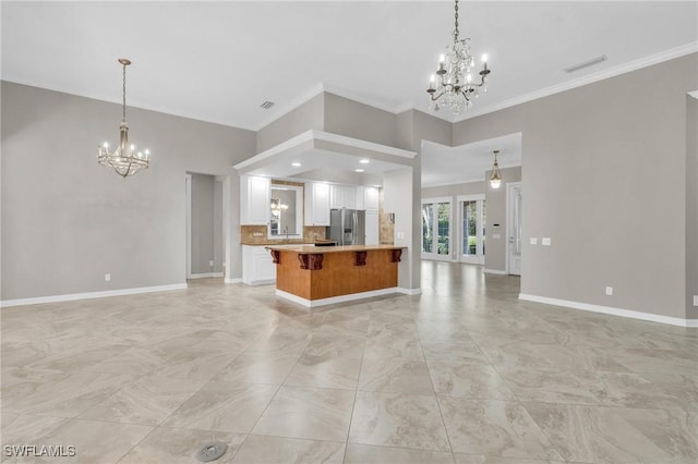 kitchen featuring an inviting chandelier, decorative light fixtures, stainless steel fridge, and tasteful backsplash