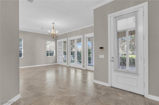 tiled entrance foyer with crown molding and a chandelier