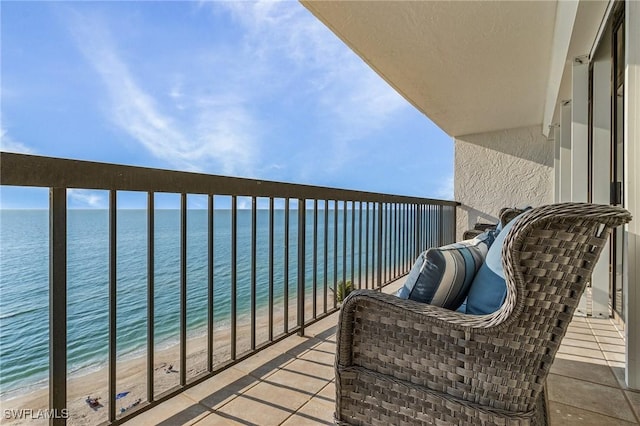 balcony featuring a water view and a beach view