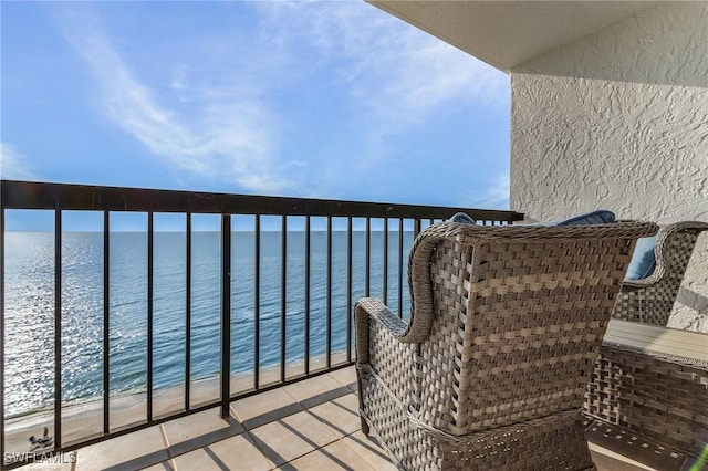 balcony featuring a water view and a view of the beach