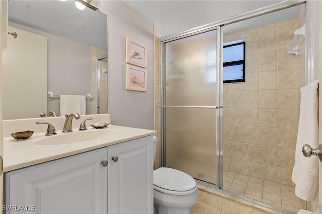 bathroom featuring vanity, a shower with shower door, tile patterned flooring, and toilet