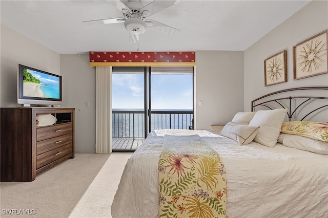 bedroom featuring access to exterior, a water view, light colored carpet, and ceiling fan