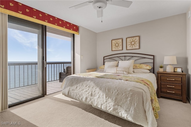 bedroom with ceiling fan, access to exterior, light carpet, and a water view