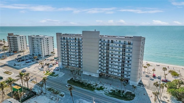 birds eye view of property with a water view and a beach view